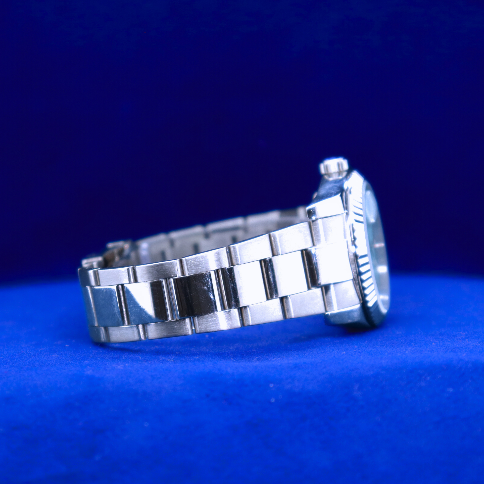 Right side view of sleek blue dial watch, half iced out custom style with shimmering side bezel and deep-toned dial