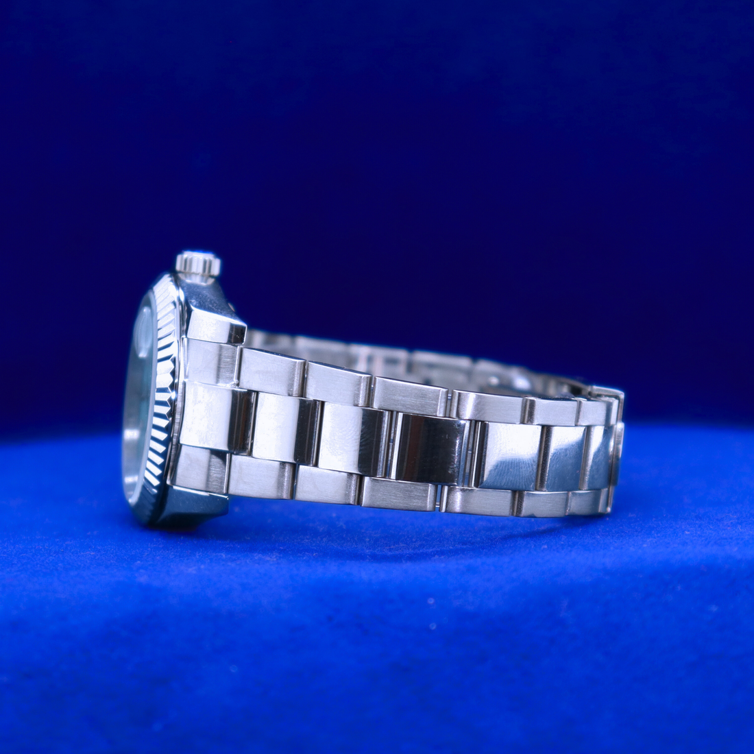 Front view of sleek blue dial half iced out custom watch with a clean luxury design and polished silver case

